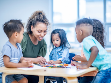 woman at table with young children in daycare